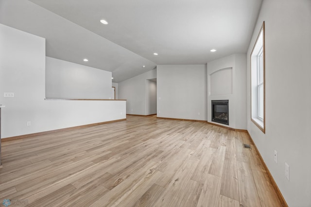 unfurnished living room with vaulted ceiling and light hardwood / wood-style flooring