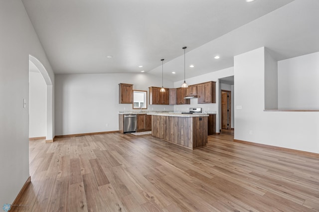 kitchen featuring pendant lighting, a center island, stainless steel appliances, high vaulted ceiling, and light hardwood / wood-style flooring