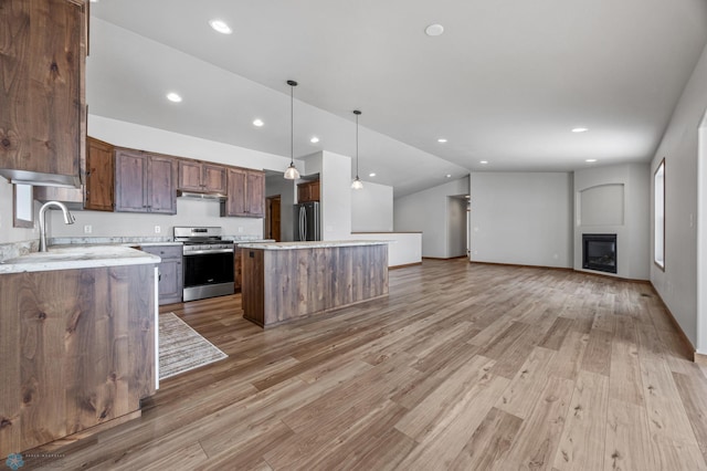 kitchen with a kitchen island, decorative light fixtures, stainless steel appliances, a fireplace, and sink