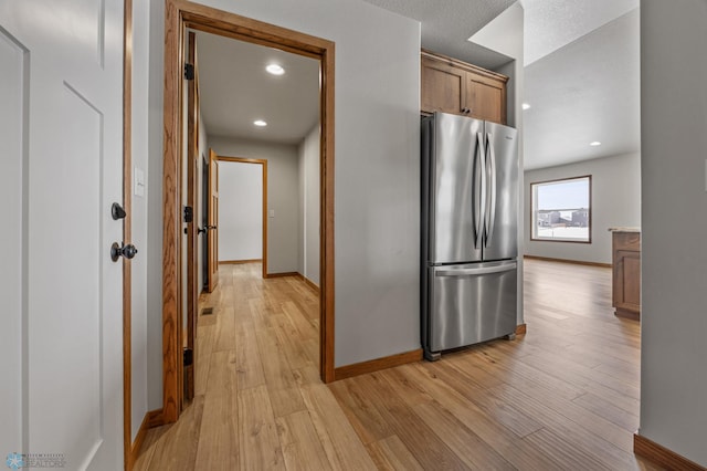 kitchen featuring stainless steel refrigerator and light hardwood / wood-style flooring