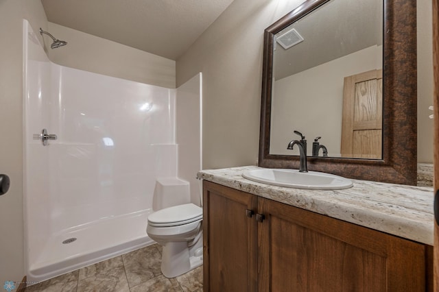 bathroom featuring toilet, walk in shower, and vanity