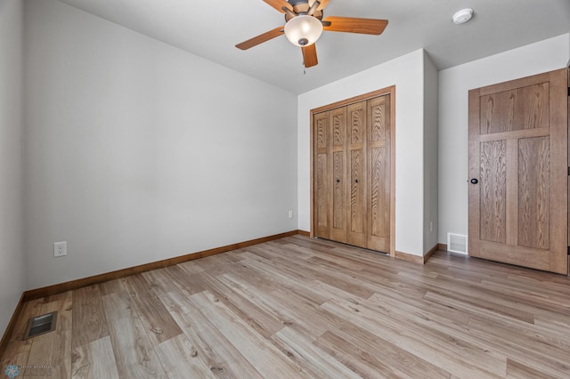 unfurnished bedroom featuring ceiling fan, light hardwood / wood-style floors, and a closet