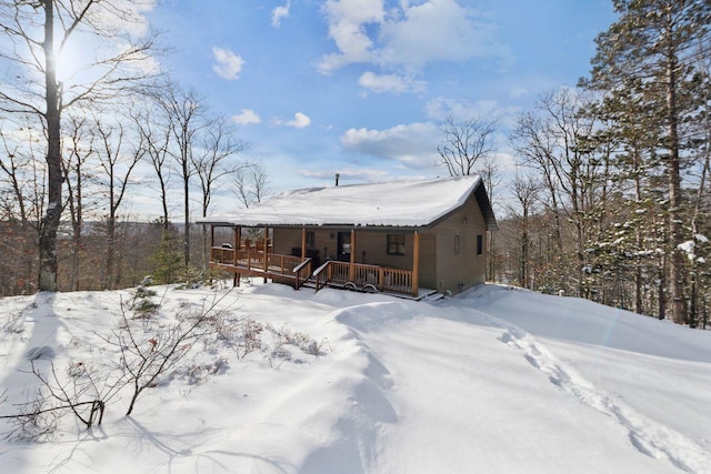 snow covered house featuring covered porch