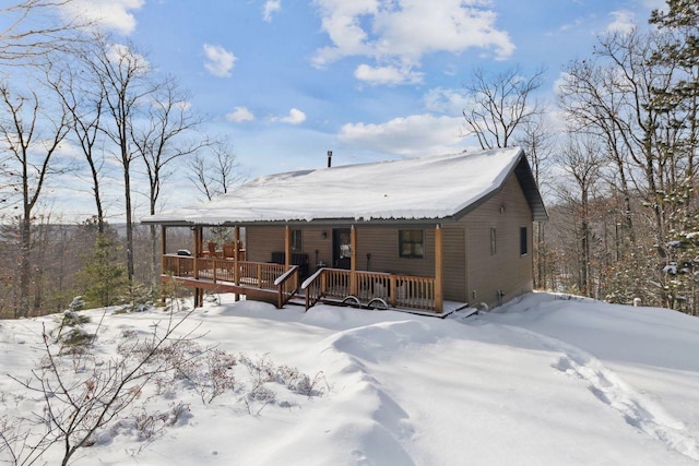 snow covered property featuring a porch