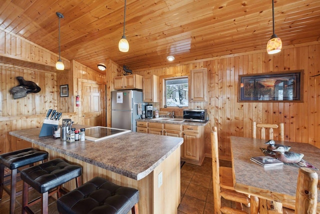 kitchen with stainless steel appliances, dark tile patterned floors, pendant lighting, and light brown cabinets