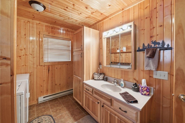 bathroom with wood walls, baseboard heating, and separate washer and dryer