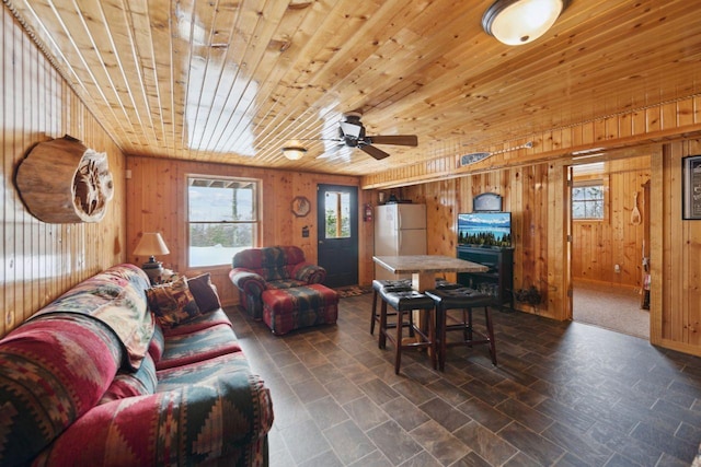 living room with wood walls, ceiling fan, and wood ceiling