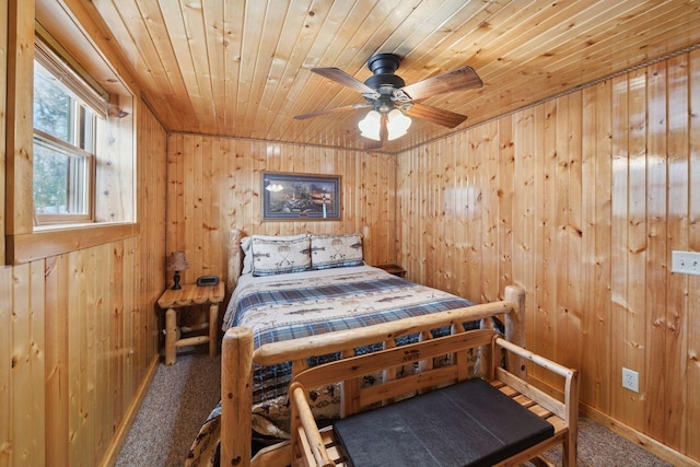 carpeted bedroom with ceiling fan, wooden walls, and wood ceiling