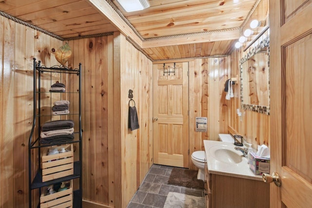 28255 Friendly Valley Rd, Washburn, WI 54891 - half bath featuring wooden ceiling, wooden walls, vanity, toilet, and stone finish flooring