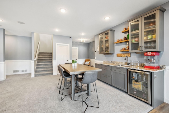 carpeted dining space with beverage cooler and indoor wet bar