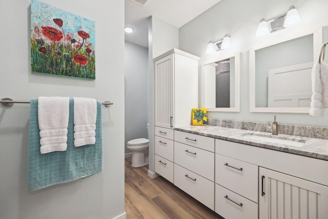 bathroom featuring vanity, hardwood / wood-style floors, and toilet