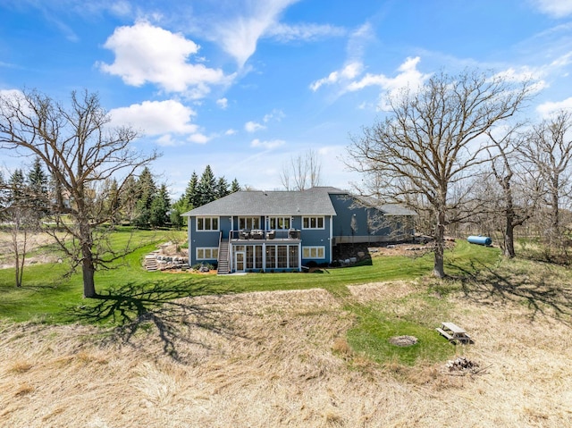 rear view of property with a yard and a deck