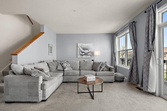 9668 Unity Ln N, Brooklyn Park, MN 55443 - living area with healthy amount of natural light, carpet, a textured ceiling, and stairs