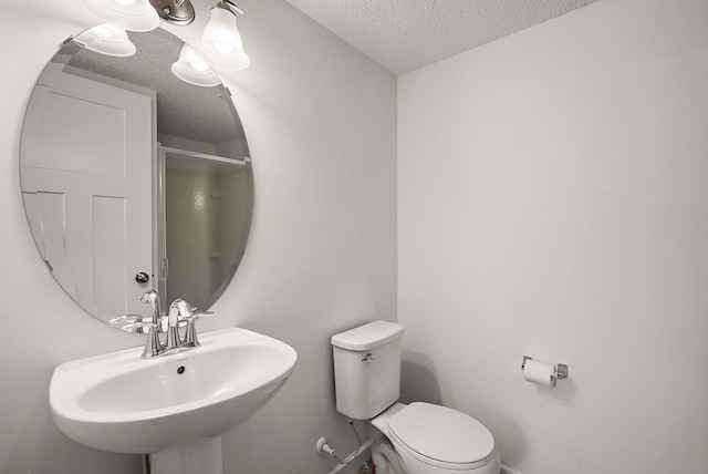 9668 Unity Ln N, Brooklyn Park, MN 55443 - full bath featuring a textured ceiling, toilet, a sink, and a shower with shower door