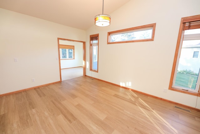 spare room with light hardwood / wood-style flooring and vaulted ceiling