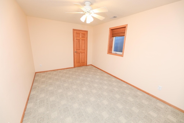 carpeted spare room featuring ceiling fan