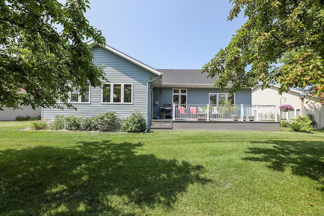 rear view of house with a deck and a lawn