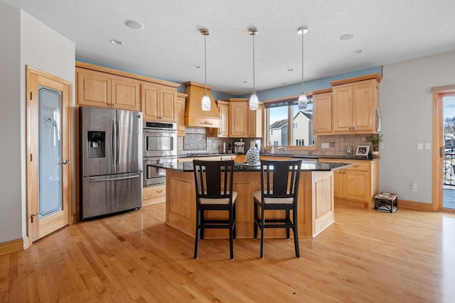 kitchen featuring appliances with stainless steel finishes, a center island, backsplash, and plenty of natural light