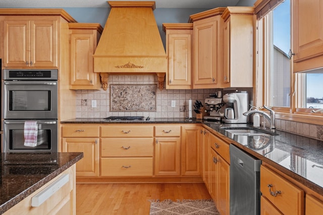 kitchen featuring stainless steel appliances, sink, custom range hood, and backsplash