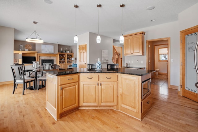 kitchen featuring hanging light fixtures, light hardwood / wood-style floors, and a center island