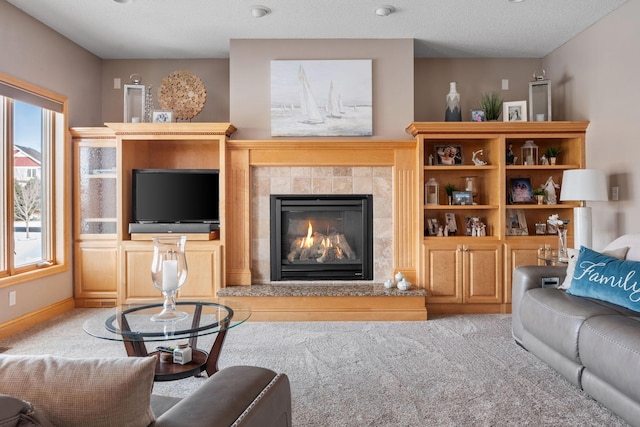 carpeted living room with a tile fireplace