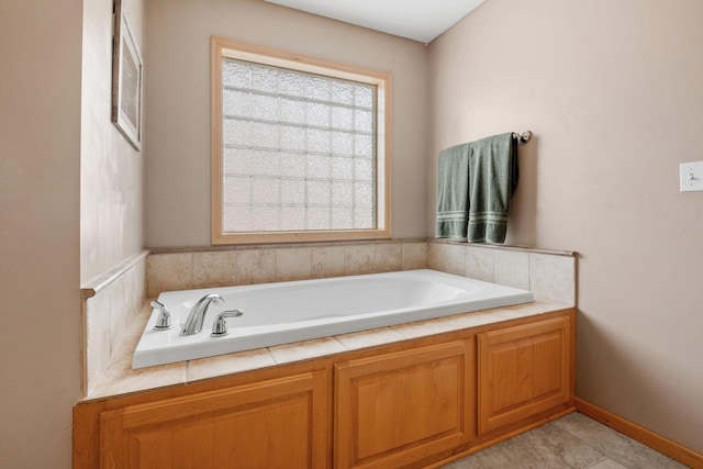 bathroom with a tub to relax in and tile patterned floors