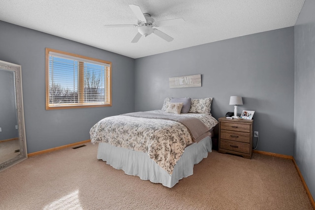 carpeted bedroom featuring ceiling fan and a textured ceiling