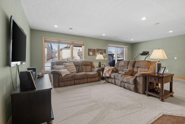 living room featuring a healthy amount of sunlight, a textured ceiling, and carpet