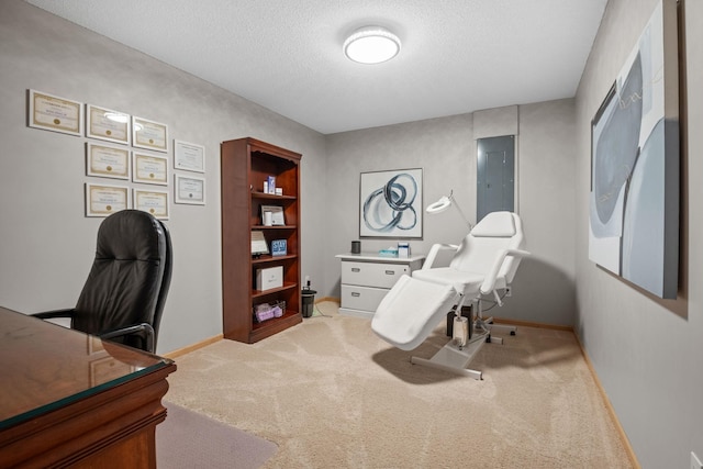 office area with light colored carpet, electric panel, and a textured ceiling