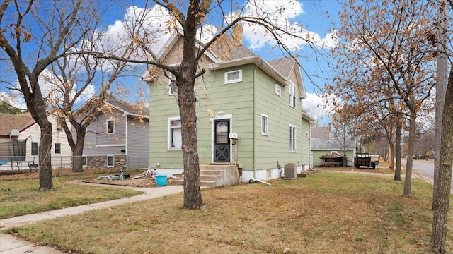 view of front of home with a front lawn and central AC unit