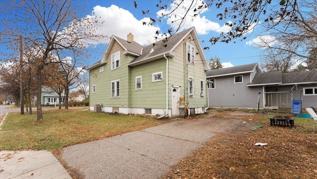 exterior space with a lawn and central AC