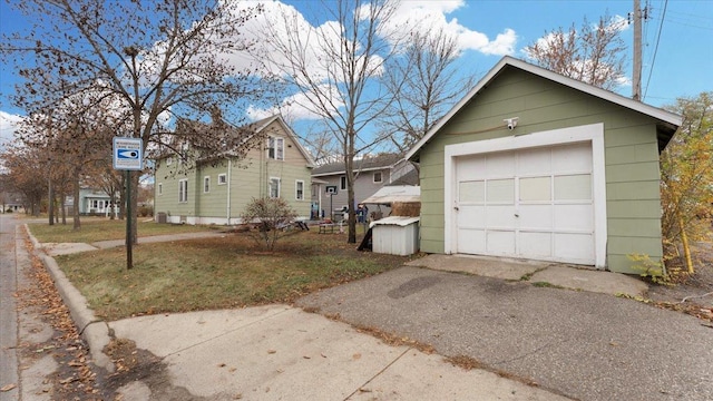 view of front of property featuring a front yard, a garage, and an outdoor structure