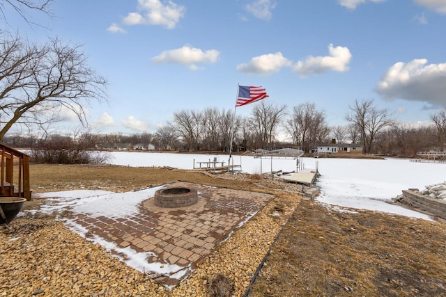 yard covered in snow with an outdoor fire pit