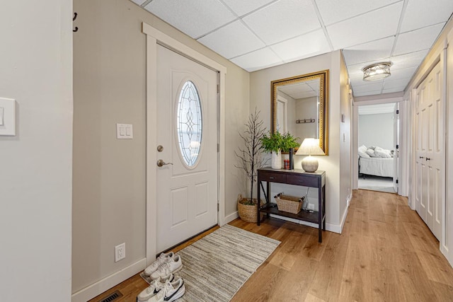 foyer with a drop ceiling and light hardwood / wood-style floors