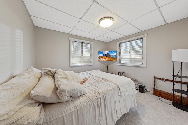 bedroom with carpet floors and a paneled ceiling