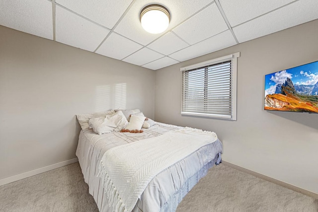 bedroom featuring light carpet and a drop ceiling