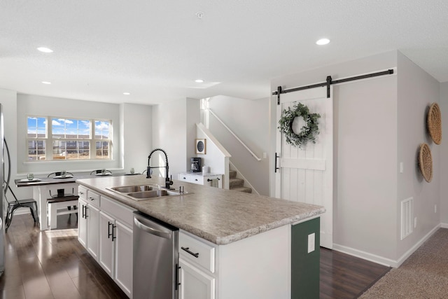 kitchen featuring sink, dishwasher, white cabinetry, an island with sink, and dark hardwood / wood-style flooring