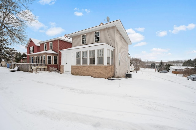 snow covered property featuring a sunroom