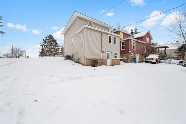 snow covered property featuring central AC