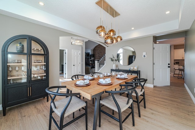 dining area featuring a textured ceiling and light wood-type flooring