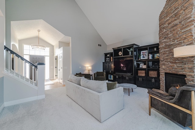 carpeted living room with a stone fireplace and high vaulted ceiling