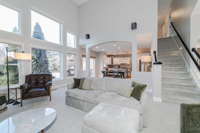 carpeted living room with a high ceiling and a wealth of natural light