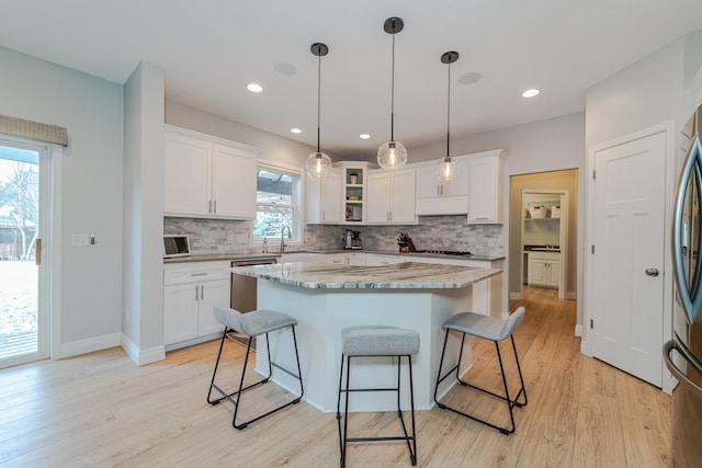 kitchen with pendant lighting, a center island, and white cabinets