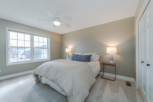 carpeted bedroom featuring ceiling fan and a closet