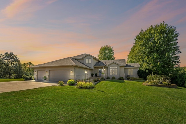 traditional home featuring a garage, a yard, and driveway