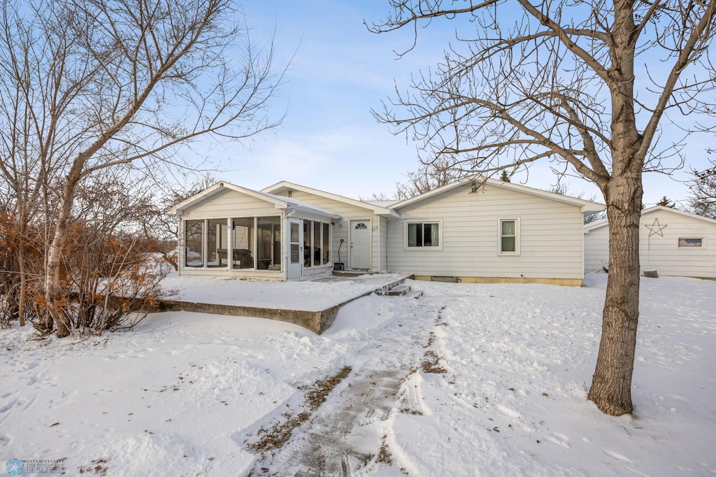 snow covered house with a sunroom