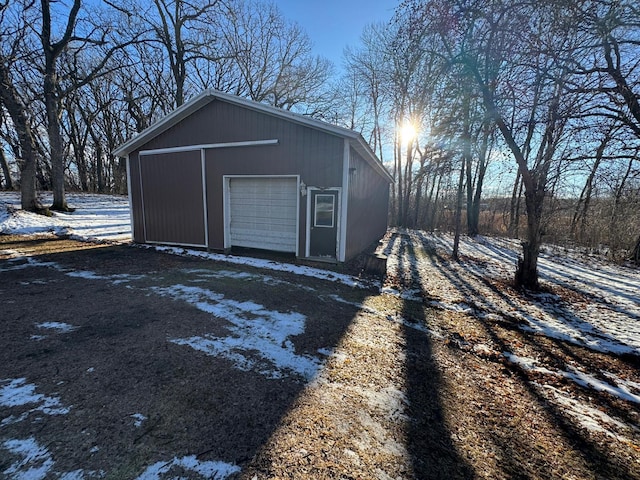 snow covered structure with a garage