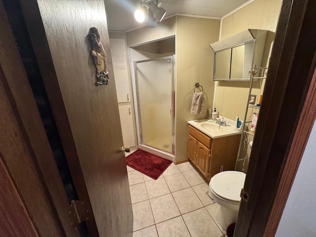 bathroom with tile patterned flooring, vanity, toilet, ornamental molding, and a shower with shower door