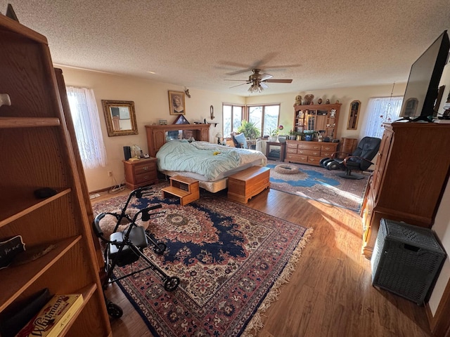 bedroom featuring a textured ceiling, ceiling fan, and hardwood / wood-style floors