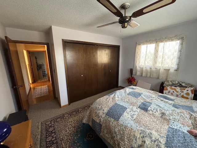 carpeted bedroom featuring ceiling fan, a textured ceiling, and a closet